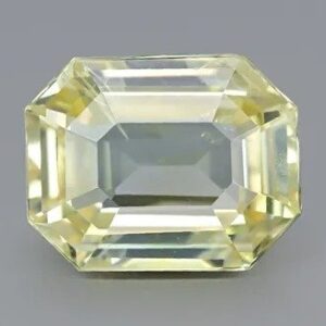 This image displays a faceted, square-shaped yellow sapphire with a bright and translucent appearance. The gemstone exhibits a rich yellow color with natural inclusions, commonly used in fine jewelry and valued for its astrological significance in some cultures.